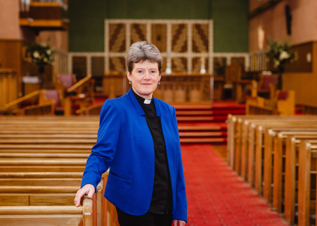 Dean Di Woods in central aisle with Aotearoa Chapel behind